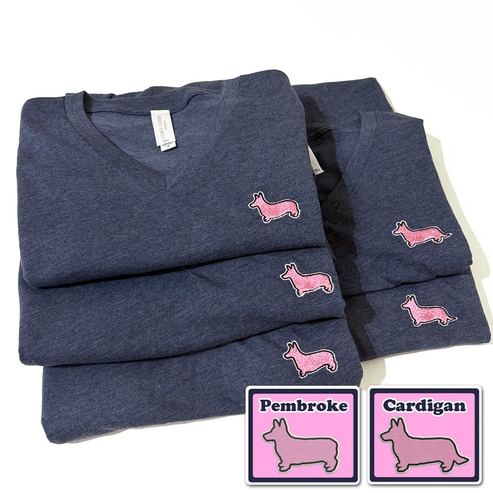 Folded navy blue shirts with pink dog embroidered logo on a white background